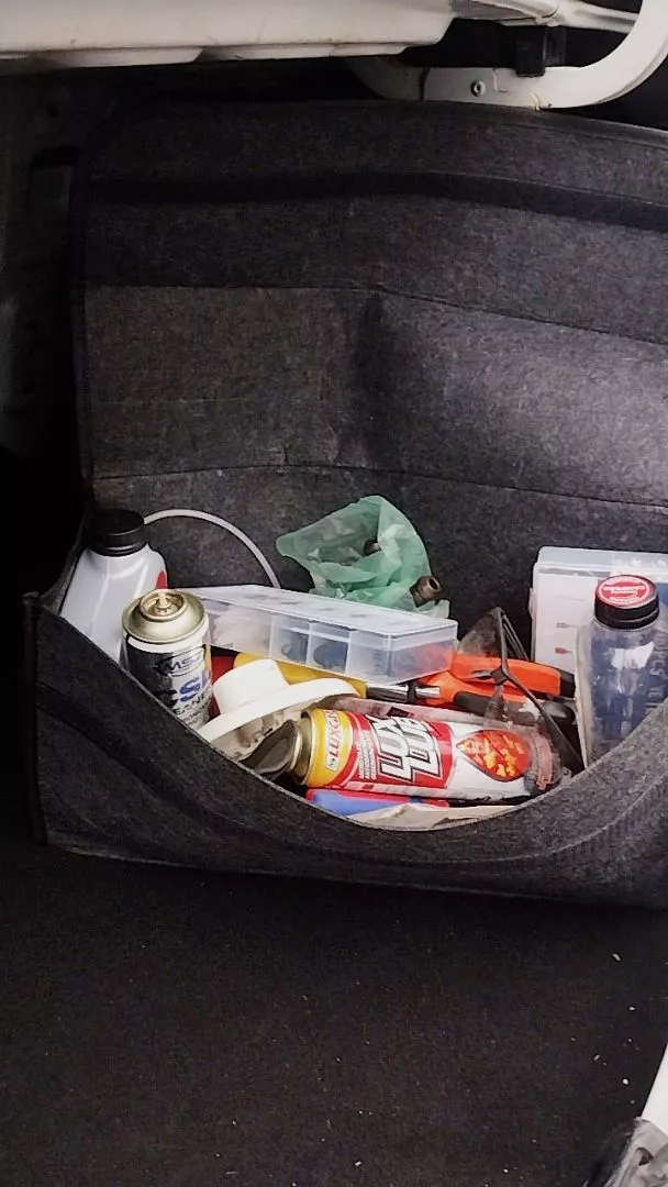 Foto de cliente: organizador aberto no porta-malas, cheio de frascos, sprays, ferramentas e uma caixa de peças